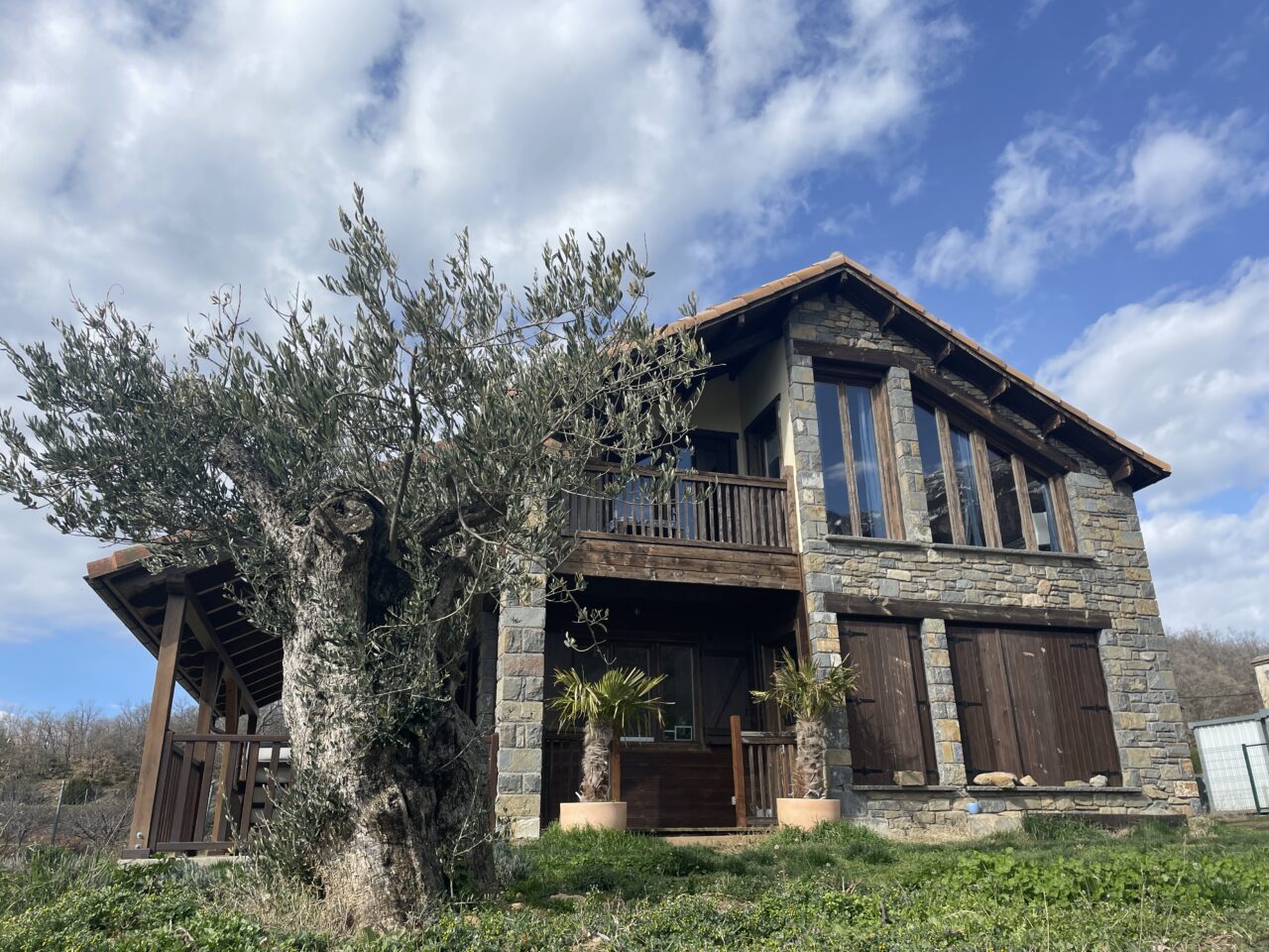 Fachada de piedra y madera de La Casa del Plano