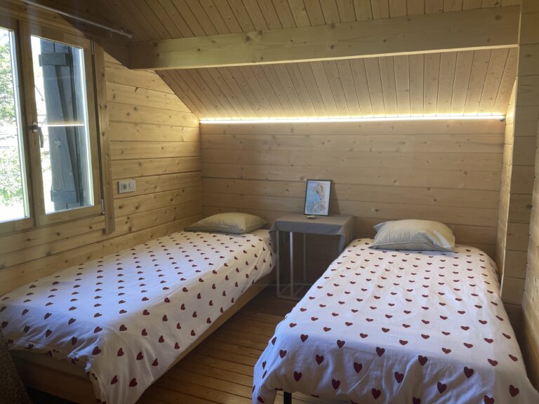 Two beds beneath the timber ceiling